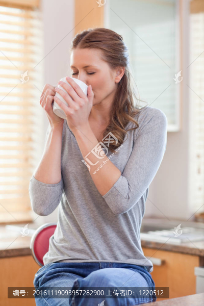 在廚房里用咖啡放松的女人