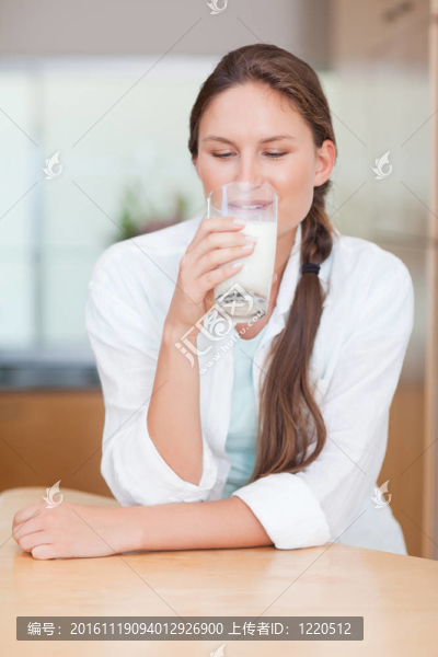 微笑的女人喝牛奶的肖像