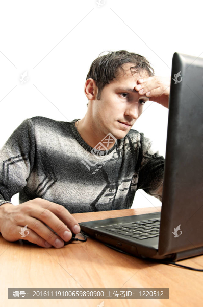 疲倦的男人看著筆記本電腦屏幕