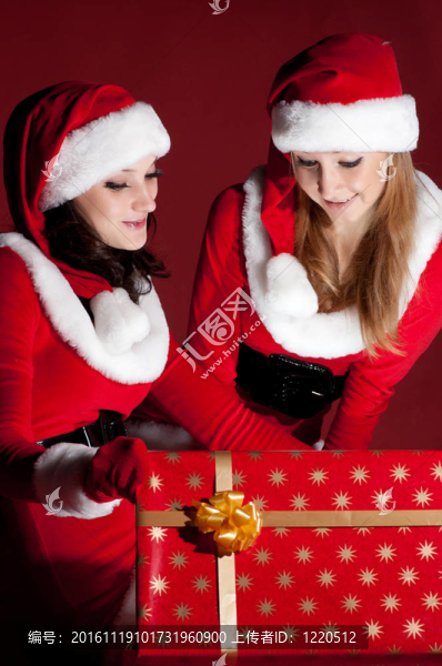兩位女性在Santa服裝店開(kāi)啟圣誕禮物。