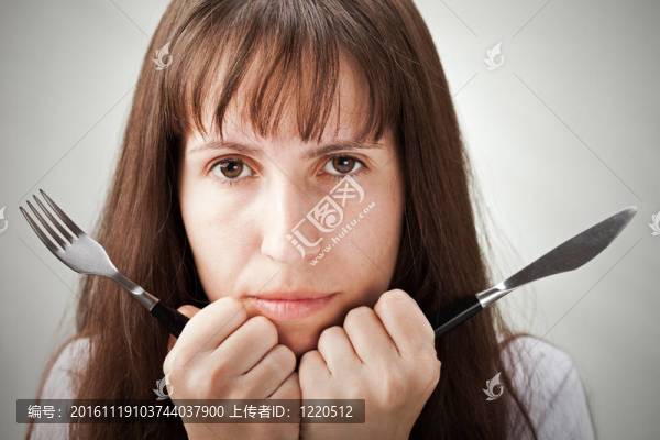 女性手拿叉和刀