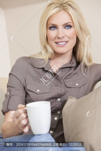 美麗的金發(fā)女人在家喝茶或咖啡