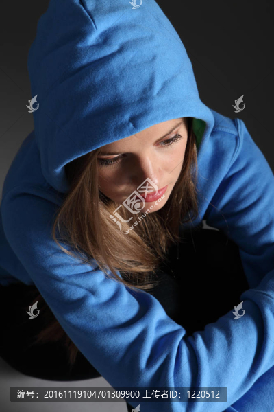 悲傷的少女獨(dú)自在地板上的藍(lán)色帽衫