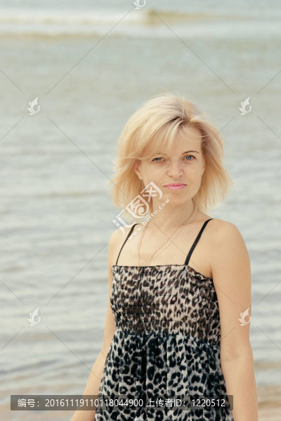 美麗的女人在海灘上擺姿勢