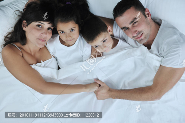 快樂的年輕家庭在他們的臥室里