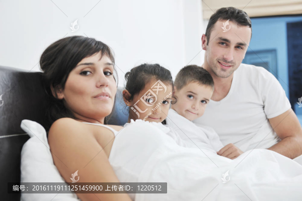 快樂的年輕家庭在他們的臥室里