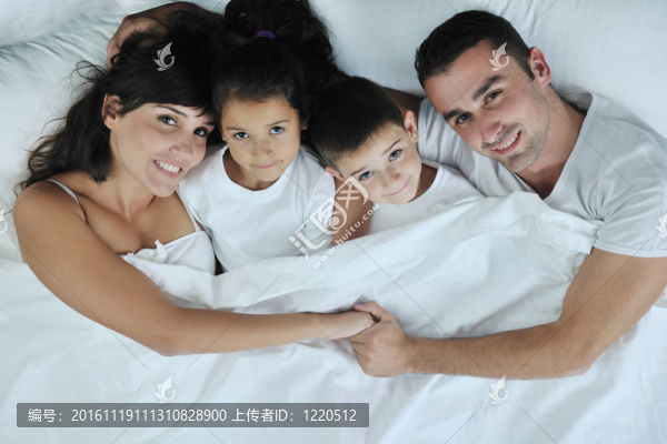 快樂的年輕家庭在他們的臥室里