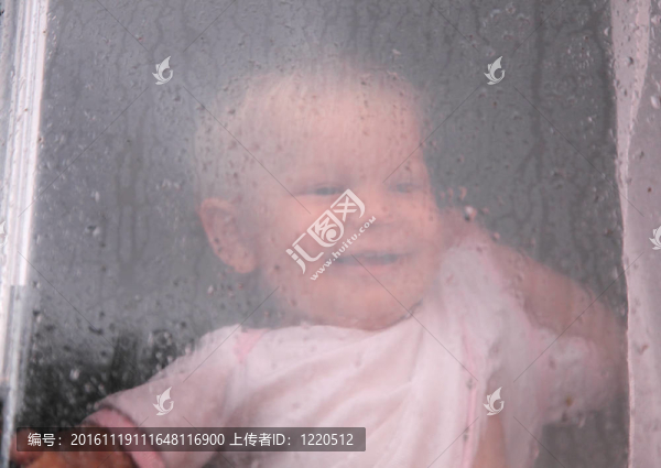 可愛的孩子看著窗外的雨滴