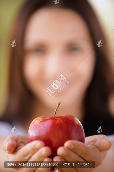 年輕的女人伸展蘋果