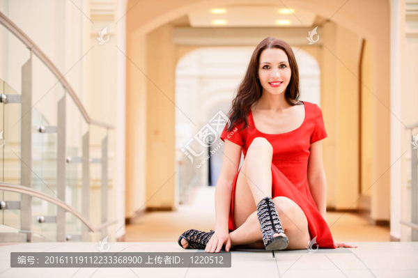 美麗的女孩坐在地板上