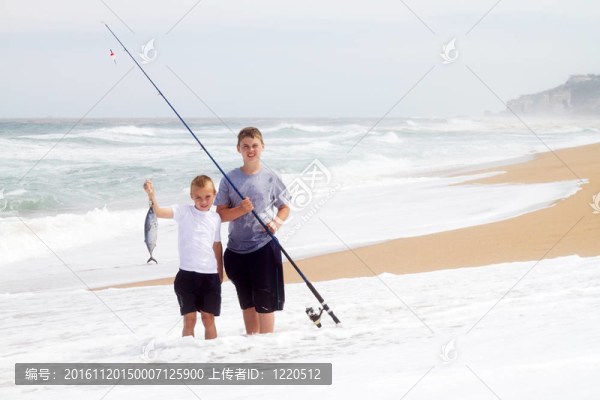 兩個男孩在海灘上捉一條大魚