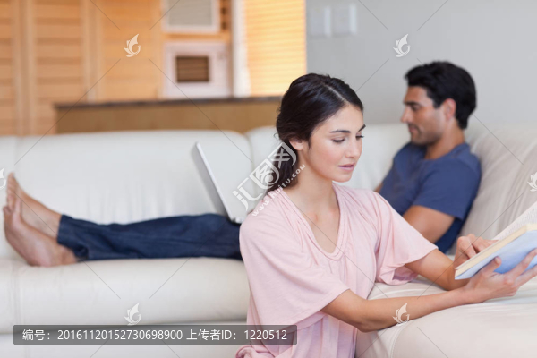 當(dāng)未婚夫正在使用筆記本電腦時(shí)，女人正在看書