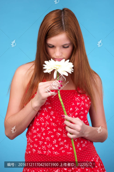 漂亮的年輕女人在嗅白色的花