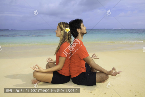 年輕夫婦在海灘上冥想