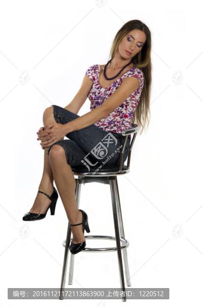 漂亮的女孩坐在酒吧的凳子上