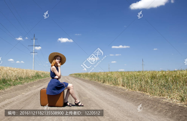 鄉(xiāng)村路上帶著手提箱的寂寞女孩。