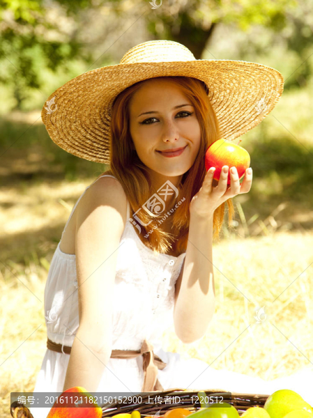美麗的紅發(fā)女孩在花園里的果實(shí)。