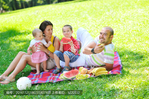 快樂的年輕夫婦和他們的孩子在公園玩得開心