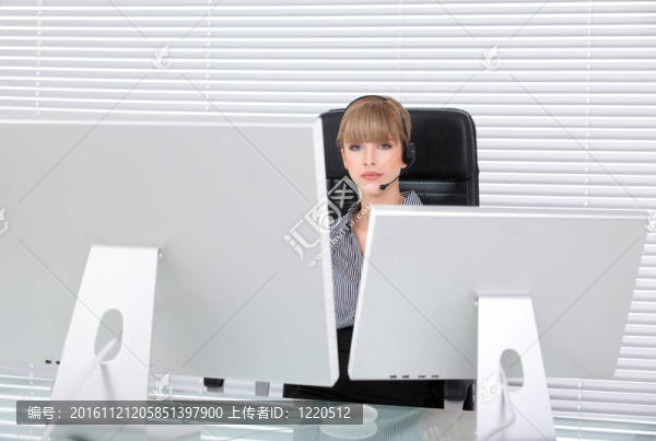 年輕的商業(yè)女性在她的辦公室與頭手機(jī)