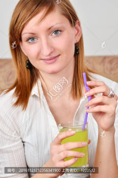 美麗的年輕女人喝果汁