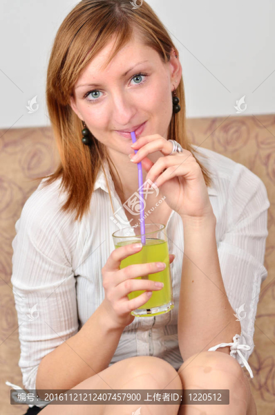 美麗的年輕女人喝果汁