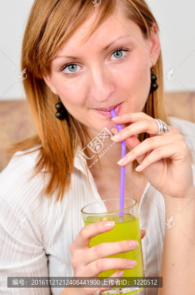 美麗的年輕女人喝果汁