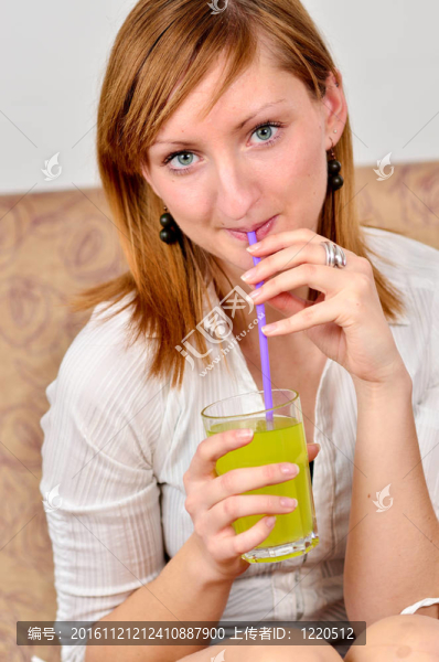 美麗的年輕女人喝果汁