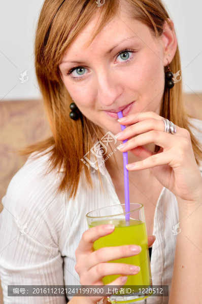 美麗的年輕女人喝果汁