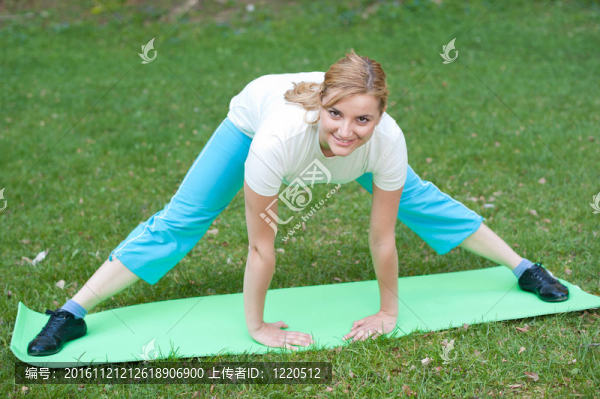 迷人的年輕女子在公園伸展肌肉