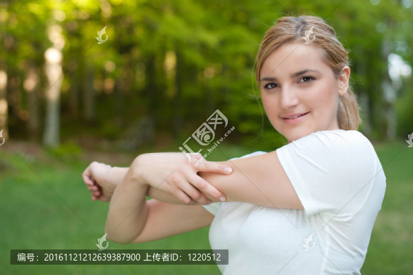迷人的年輕女子在公園伸展肌肉