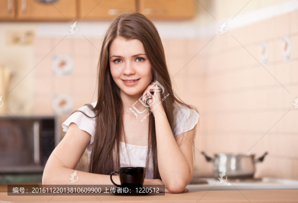美麗快樂(lè)的年輕女子在家喝咖啡