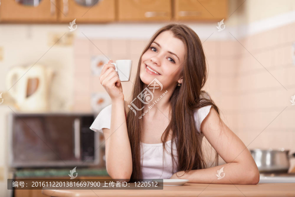 美麗快樂(lè)的年輕女子在家喝咖啡
