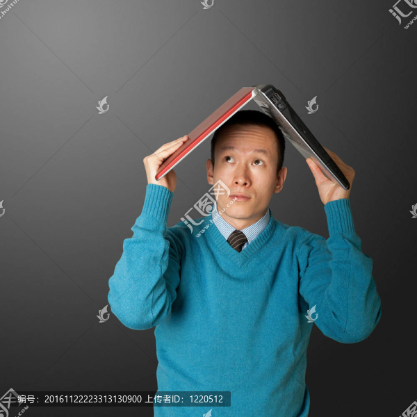 年輕商人藏在筆記本電腦下