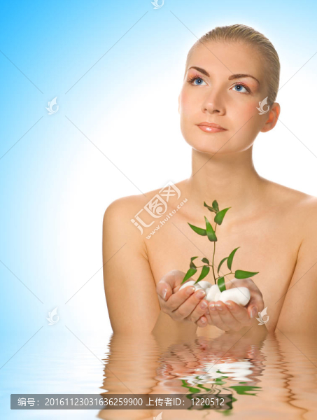 美麗的年輕女子站在水中的小植物
