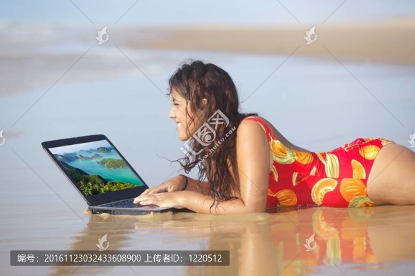 女人在海灘上使用筆記本電腦