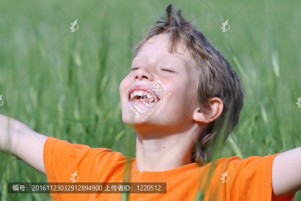 快樂微笑的孩子張開雙臂閉著眼睛享受夏日的陽光