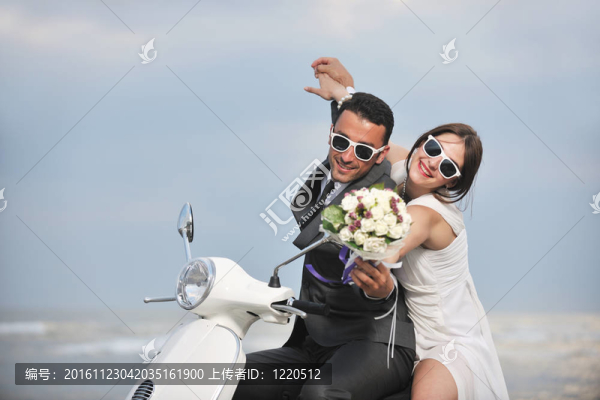 只是夫婦在海灘上騎白色滑板車