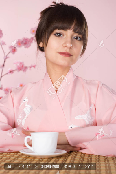 美麗的女孩坐在一個(gè)粉紅色的