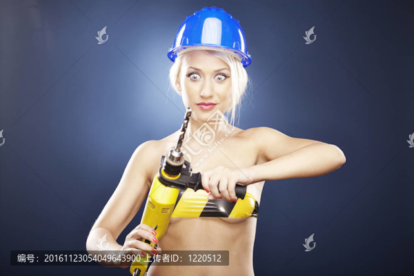 驚訝的女孩與電鉆和頭盔