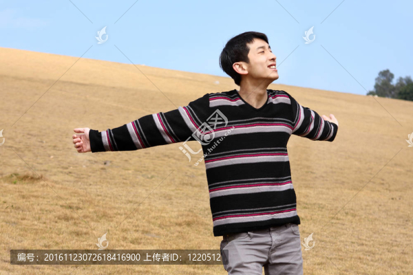 Carefree的男人站在金色草地快樂享受休閑時(shí)光