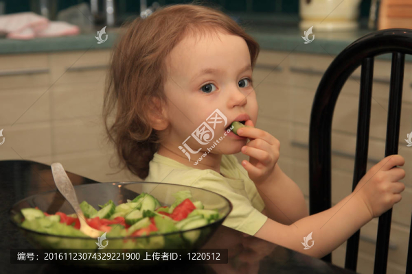 一個女孩吃蔬菜沙拉。
