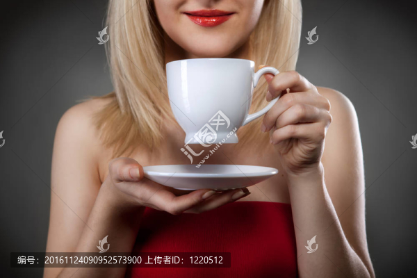 女人在紅色的捧著杯子和微笑