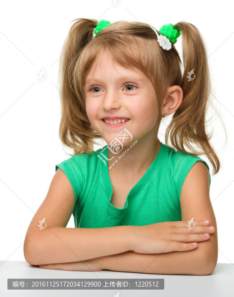 快樂的小女孩正坐在桌子旁