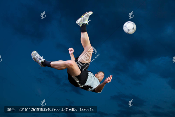 在自行車踢中的足球運動員