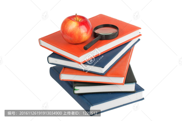 成熟的蘋果和放大鏡放在一堆書上