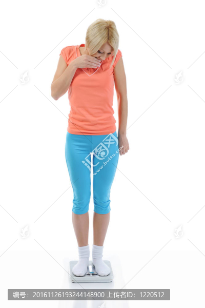 年輕的體育女孩站在秤上