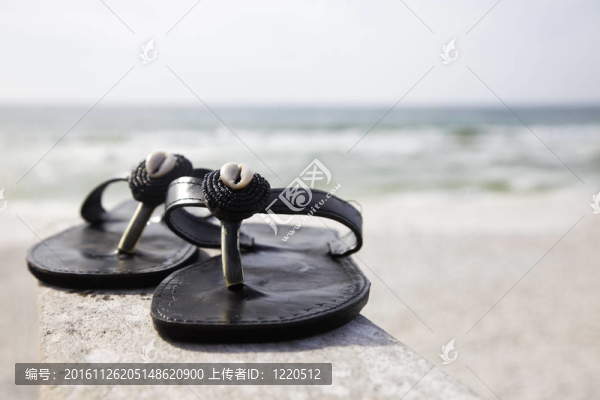 海灘上的黑色拖鞋