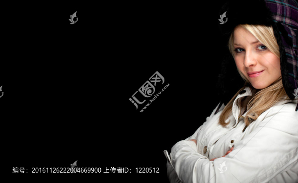 年輕漂亮的金發(fā)女人戴著溫暖的冬帽和明亮的外套；黑色背景