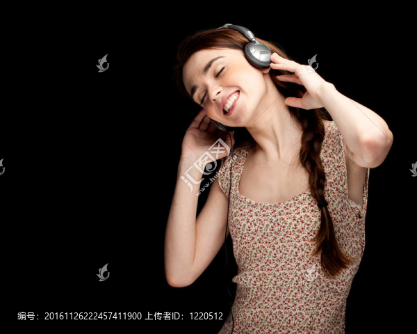 扎馬尾辮的年輕婦女；戴耳機(jī)聽(tīng)音樂(lè)