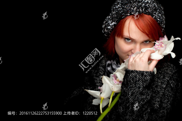 可愛的冬天穿著蘭花的女人；黑色背景
